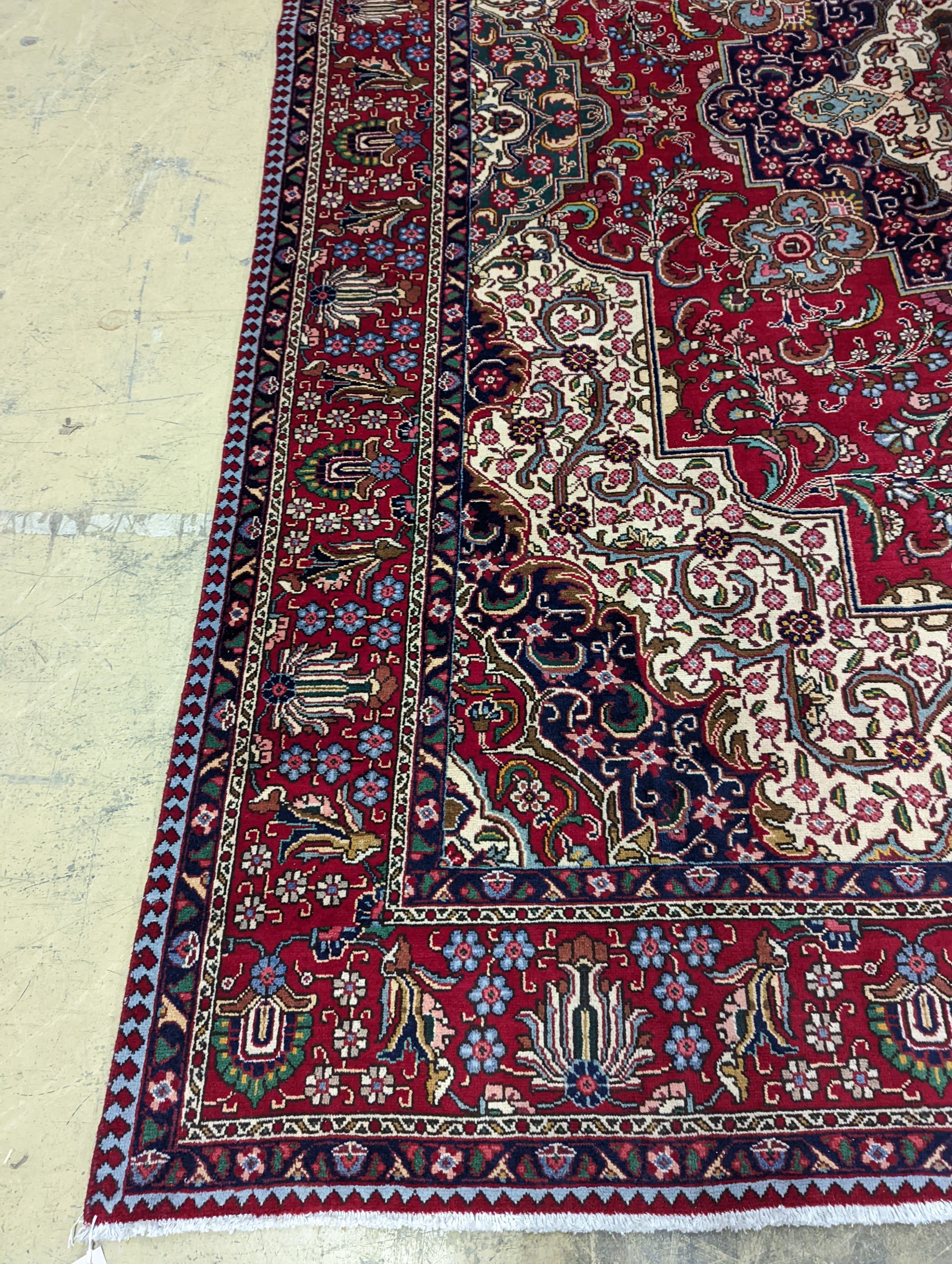 A Tabriz red ground carpet, 405 x 292cm